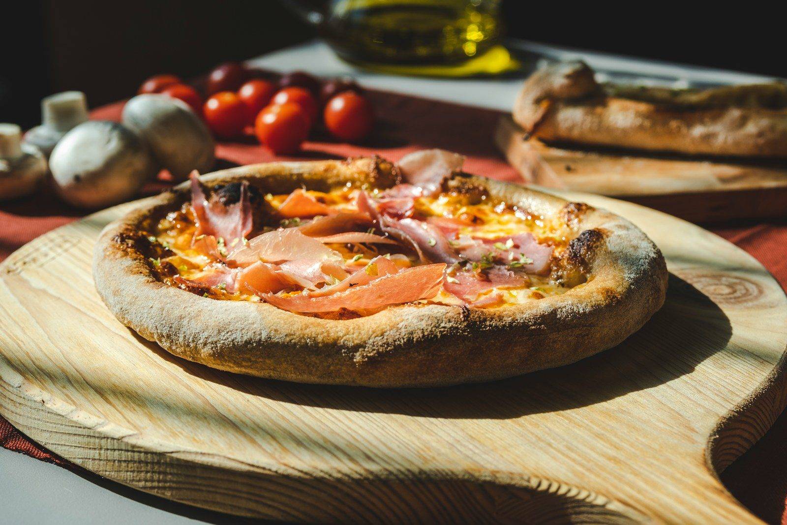 a pizza sitting on top of a wooden cutting board